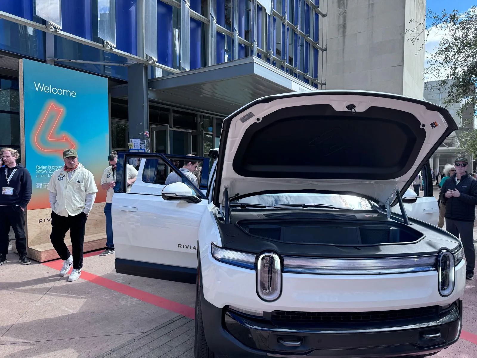 SUV modelo R1S da Rivian estacionado em frente ao centro de convenção de Austin durante o SXSW de 2025